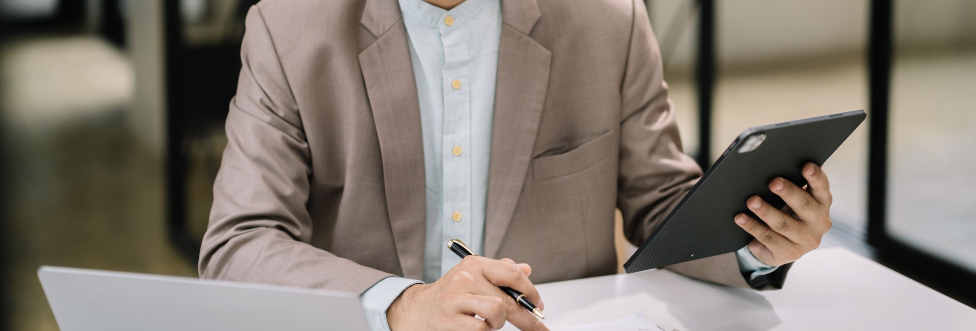 Serious young man sit at workplace desk in office use calculator calculates monthly expenses, taxes, personal budget management concept